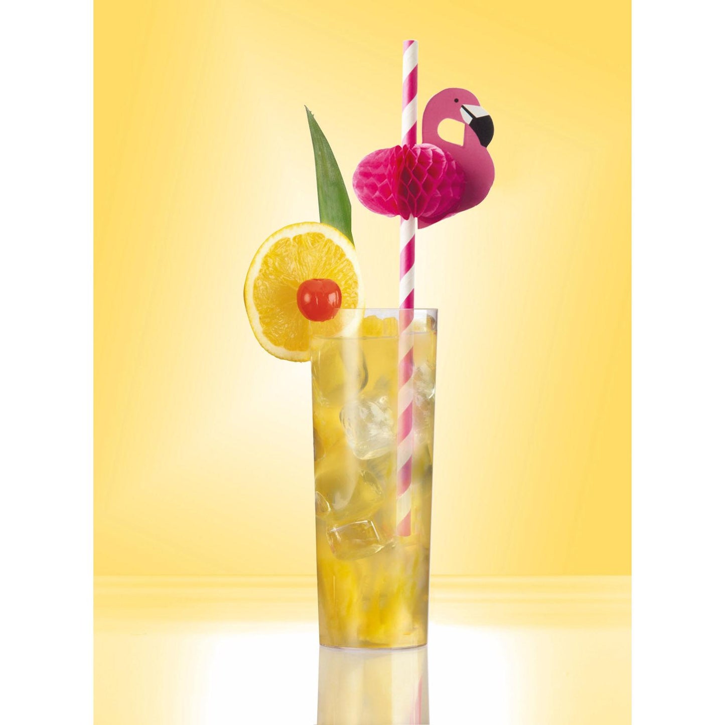 Un grand verre avec une boisson glacée jaune, décoré d'une tranche de citron, d'une cerise, d'une feuille verte et d'une paille en papier rayée rose PAPSTAR (6 mm x 20 cm) avec un flamant rose en papier sur fond jaune. Marque : PAPSTAR GmbH.