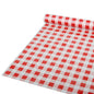 Sur une surface plane, une nappe Starpak partiellement déroulée, film 50 m x 80 cm rouge « Karo » (1 rouleau), avec un motif à carreaux rouge et blanc est représentée ; le matériau semble être un film plastique.