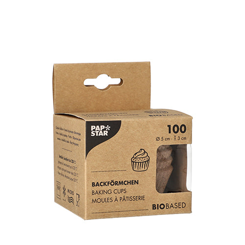 Une boîte marron de la société PAPSTAR avec l'inscription « PAPSTAR 100 moules à pâtisserie ronds » contient 100 moules à pâtisserie biosourcés (5 x 3 cm). L'avant montre une illustration de cupcake, le nom du produit en trois langues et une fenêtre qui montre les moules qu'elle contient.