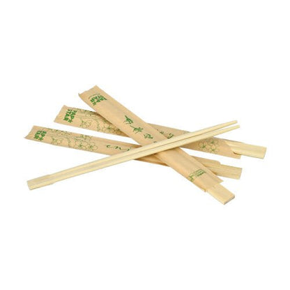 Plusieurs paires de baguettes en bambou "pures" de PAPSTAR GmbH, 21 cm, chacune emballée individuellement dans du film plastique, sont étalées sur un fond blanc ; certaines paires ont des manches avec des motifs verts et du texte.
