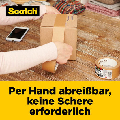 Une personne déchire à la main le ruban d'emballage en papier Scotch® Box Lock™ pour fermer une boîte sur une table en bois. On voit un rouleau de ruban adhésif, un smartphone et des textiles pliés. Le texte allemand met en avant la fonction Easy-Tear de 3M Deutschland GmbH.