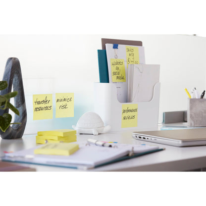 Auf einem weißen Schreibtisch mit Büromaterial und einer weißen Ordnerablage sind Post-it® Super Sticky Z-Notes (Gelb, 76x127mm, 90 Blatt/Block, 12 Blöcke/Packung) der 3M Deutschland GmbH für Aufgaben beschriftet, daneben eine kleine weiße Schildkrötenfigur.