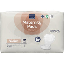 Un paquet de serviettes maternité ABENA, Premium de Abena Re-Seller GmbH contient 15 serviettes douces et absorbantes pour la période post-partum, dont les symboles de certification sont visibles sur l'emballage.