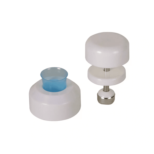 Sur un fond blanc, on aperçoit deux ustensiles de cuisine blancs en plastique. L'ustensile de gauche est de forme cylindrique et comporte un insert en plastique bleu, tandis que celui de droite est un broyeur à comprimés AMPri destiné aux gobelets à médicaments de la société AMPri Handelsgesellschaft mbH ; il se compose de deux disques blancs reliés par une tige en acier inoxydable dotée d'une base métallique.