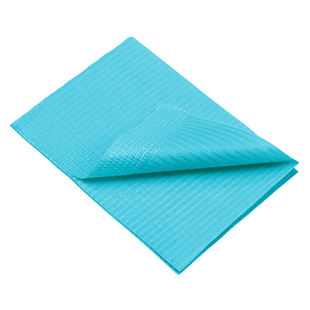 Une bâche bleue pliée, dont la texture ressemble à celle des serviettes de patient jetables AMPri Dental d'AMPri Handelsgesellschaft mbH, est illustrée sur un fond blanc. Un coin est légèrement soulevé, rendant visible le dessous tissé.