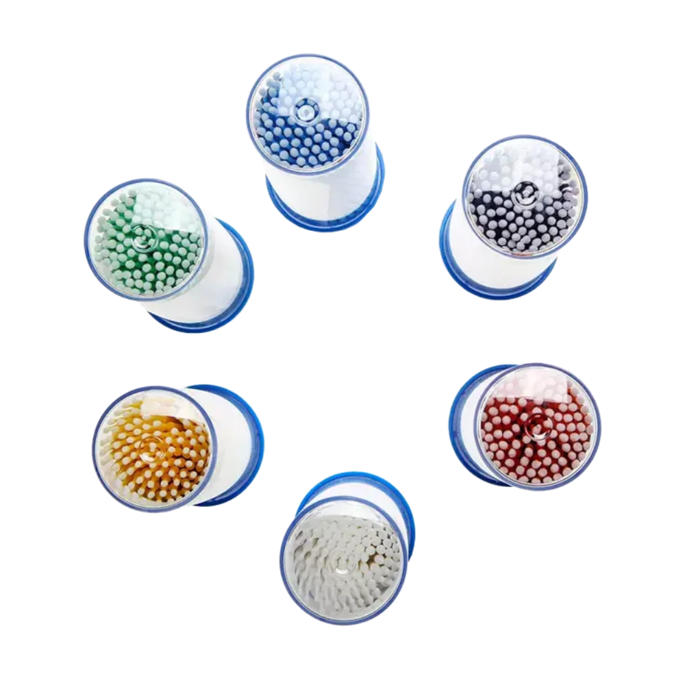 Les micro-applicateurs jetables AMPri MED-COMFORT, disponibles en différentes couleurs, sont disposés en cercle et équipés de poils en bleu, blanc, noir, vert, jaune et rouge. Chaque applicateur a une base bleue et est visible d'en haut. Cette disposition est idéale pour les besoins dentaires, nécessitant un travail précis avec divers outils codés par couleur. Présenté par AMPri Handelsgesellschaft mbH.