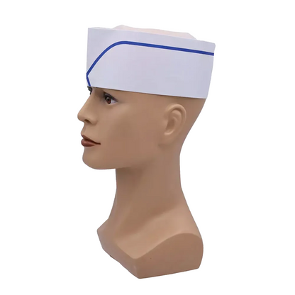 Sur la tête d'un mannequin se trouve une coiffe AMPri blanche avec couronne en non-tissé et bande bleue. Ce bonnet réglable de la gamme de produits jetables de la société AMPri Handelsgesellschaft mbH est positionné en biais sur le mannequin et illustré de profil sur un fond blanc simple.