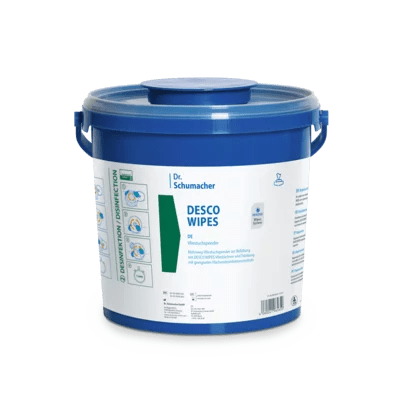 Un grand conteneur en plastique bleu avec une poignée et un couvercle rond portant l'inscription "Dr. Schumacher DESCO WIPES EIMER | Packung (6 Stück)" de la société Dr. Schumacher GmbH, avec des instructions bleues et vertes pour les lingettes désinfectantes pour le nettoyage des surfaces.
