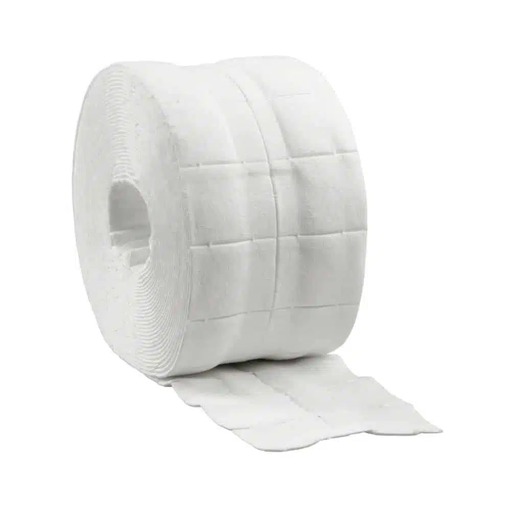 Un grand rouleau de papier toilette blanc à texture matelassée, partiellement déroulé et présenté sur un fond blanc, rappelle les tampons de cellulose absorbants B. Braun Askina® Brauncel®, utilisés pour le nettoyage doux de la peau.