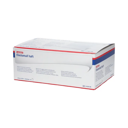 Une boîte de BSN Elastomull® haft, un bandage de gaze élastique blanc de BSN Medical GmbH, est exposée. L'emballage présente des accents bleus et rouges qui mettent en valeur l'étiquette en tant que bandage de fixation élastique. Le texte sur la boîte contient des informations et spécifications sur le produit en plusieurs langues.