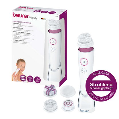 L'image montre un ensemble de brosse faciale Pureo Deep Cleansing FC 95 emballé de Beurer GmbH. L'ensemble comprend l'appareil principal pour la brosse faciale, trois têtes de brosse différentes adaptées à chaque type de peau, et un petit panneau rond violet qui met en avant l'effet nettoyant en profondeur des soins et du nettoyage du visage.