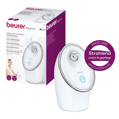 La Beurer sauna faciale ionique FC 72 Pureo Ionic Hydration de Beurer GmbH en blanc avec technologie ionique pour un effet nettoyant en profondeur est illustrée sur le devant de son emballage. L'appareil dispose d'une buse ronde et d'un bouton d'allumage bleu. L'emballage met en avant les avantages du produit en plusieurs langues et contient une étiquette ronde avec l'inscription « Rayonnant de beauté & soigné ».