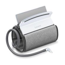 Un brassard universel enroulé Beurer pour tensiomètre BM 51 brassard avec moniteur numérique blanc connecté. Un tuyau flexible part du brassard universel et se termine par un raccord destiné à être connecté à un appareil de mesure. L'écran du moniteur légèrement incliné est partiellement visible. Convient pour des circonférences de bras de 22 à 42 cm.