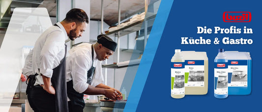 Zwei Köche in professioneller Restaurantküche bei der sorgfältigen Zubereitung eines Gerichts; rechts auf blauem Hintergrund Reinigungsprodukte der Marke Buzil (Bistro und Blitz Citro) mit dem Slogan ‚Die Profis in Küche & Gastro‘ und rotem Buzil-Logo