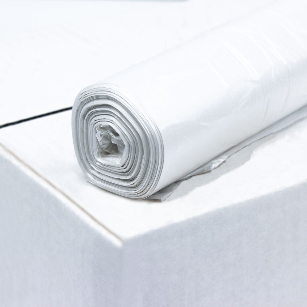 Un rouleau de sac-poubelle DEISS HDPE 80 litres, 56095, blanc de EMIL DEISS KG (GmbH + Co.) est posé sur une boîte. Le rouleau est proprement enroulé, tandis que la surface de la boîte semble lisse et propre.
