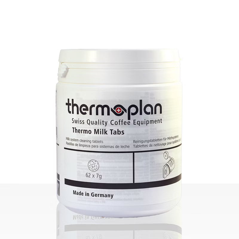 Un conteneur en plastique blanc avec l'inscription "Thermoplan Thermo Milk Tabs, tablette de nettoyage pour machines à expresso | Paquet (62 pièces)" de Diversey Deutschland GmbH & Co. OHG, pour le nettoyage hygiénique, montre "62 x 7g", "Made in Germany" et des informations multilingues.