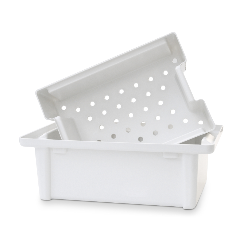 La bassine à instruments Dr. Schumacher de la Dr. Schumacher GmbH est un plateau en plastique blanc avec un insert de tamis incliné assorti avec des trous circulaires, parfait pour la désinfection des instruments médicaux.