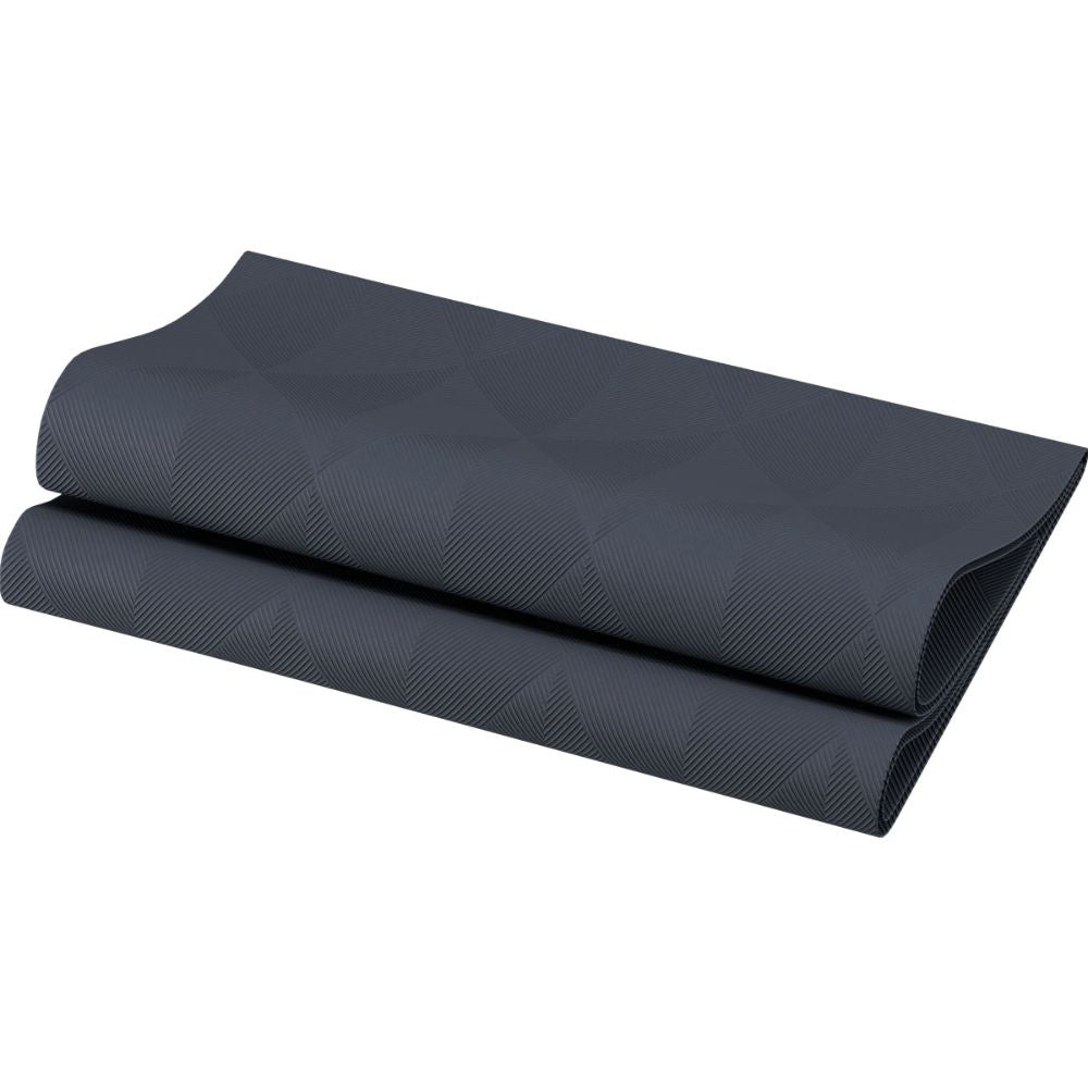 Un tapis de yoga noir finement plié avec un motif géométrique discret repose sur un fond blanc, à côté des serviettes Duni Elegance Crystal 48 x 48 cm 1/4 pli Crystal de Duni GmbH pour une touche supplémentaire de raffinement.