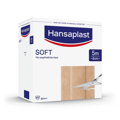 Une boîte de pansements Hansaplast Soft avec l'inscription « Peau sensible », de 5 mètres sur 6 centimètres, on voit une bande de pansement beige sur le côté. Texte sur.