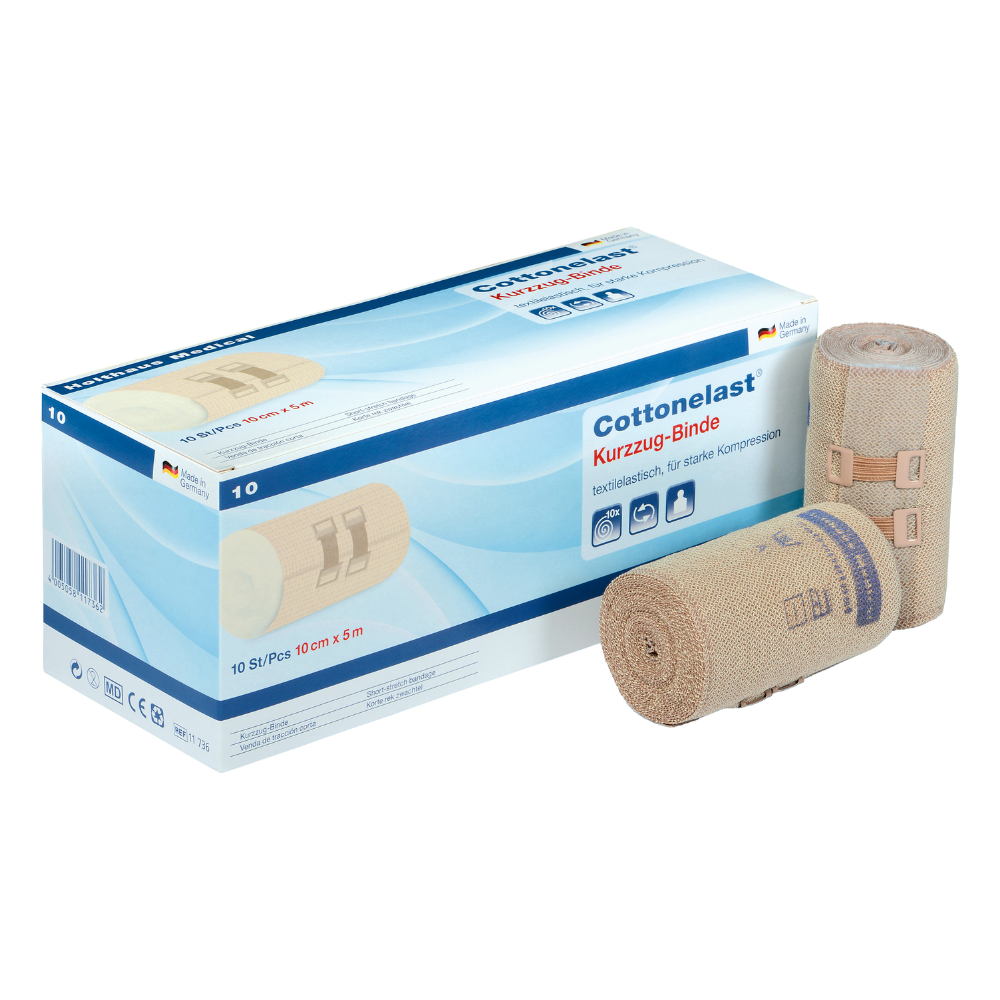 Sur l'image, on peut voir une boîte avec l'inscription « Holthaus Cottonelast® Kurzzug-Binde », accompagnée de deux bandages roulés. La boîte contient 10 bandages de compression à faible élasticité mesurant 10 cm x 5 m. Ces dispositifs médicaux de Holthaus Medical GmbH & Co. KG sont fabriqués à 100 % en coton et sont faits de tissu beige avec des coutures bleues.