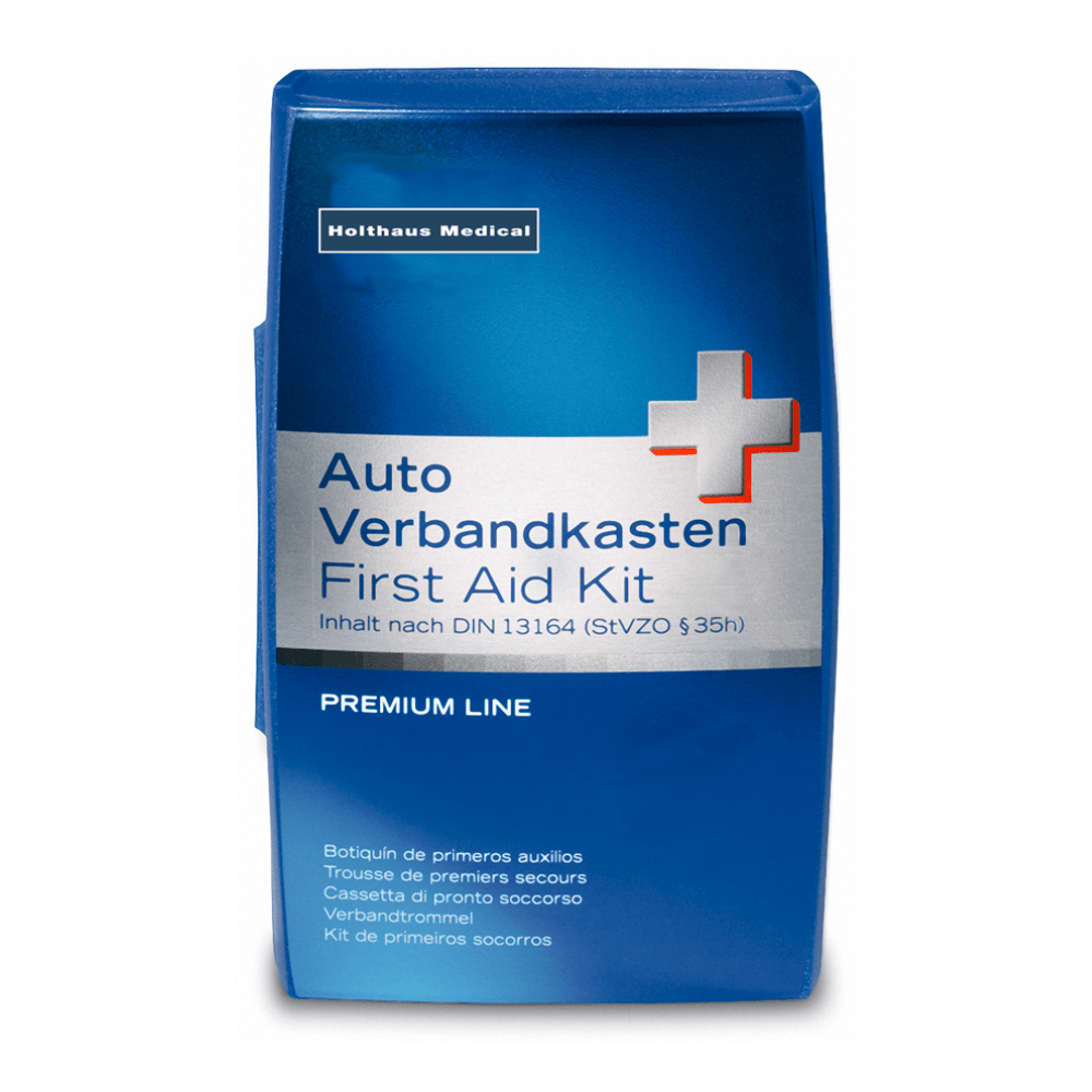 Une boîte bleu-blanc avec l'inscription « Holthaus Premium Erste-Hilfe-Set | Packung (1 Stück) » indique sa résistance aux températures et sa structure incassable. Un texte multilingue supplémentaire informe sur le contenu et la conformité à la norme DIN 13164 (StVZO §35h). Dans le coin supérieur gauche se trouve le nom de la marque « Holthaus Medical GmbH & Co. KG ».