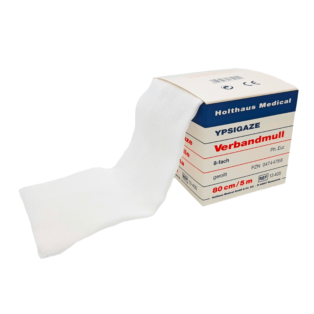 Un paquet de bandages Holthaus Ypsigaze de différentes tailles de Holthaus Medical GmbH & Co. KG contient une gaze blanche partiellement déroulée en 100% coton. L'étiquette indique que la gaze mesure 80 cm de large et 5 mètres de long, avec différents codes produits et spécifications.