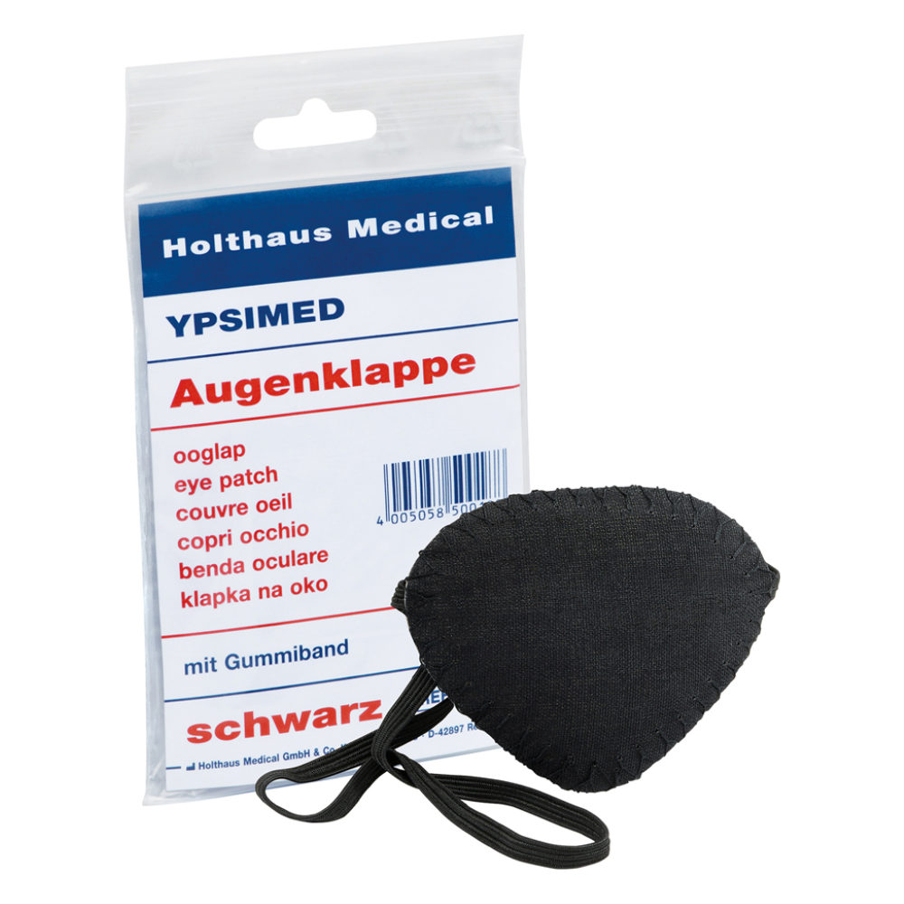 Exposé est un cache-œil Ypsimed de Holthaus, avec bande élastique, en tissu noir. À côté se trouve un emballage en plastique avec l'inscription « Holthaus Medical GmbH & Co. KG », « YPSIMED » et « cache-œil » en plusieurs langues, indiquant son utilisation comme dispositif médical pour la protection des yeux.