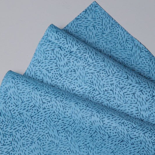 Nahaufnahme von gefalteten Kimtech® Prozeßwischtüchern (Kimberly-Clark GmbH) in blau, BRAG™ Box - 160 Blatt, mit geometrischem Strich- und Punktmuster. Ideal für die anspruchsvolle industrielle Reinigung. Ausgestellt auf einer hellgrauen Oberfläche.