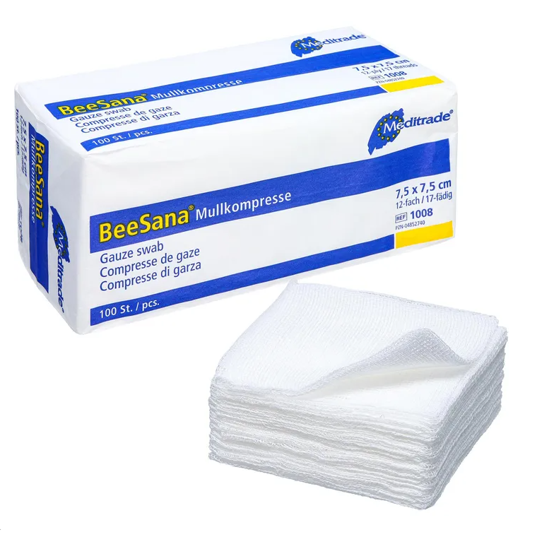 L'image montre une boîte avec l'inscription « Meditrade BeeSana® compresse de gaze, non stérile » à côté d'une pile de compresses de gaze blanches, idéales pour un soin efficace des plaies. La boîte mesure 7,5 x 7,5 cm et contient 100 pièces. Ces compresses de gaze sont soigneusement empilées devant la boîte, fabriquées par Meditrade GmbH.