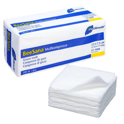 L'image montre une boîte avec l'inscription « Meditrade BeeSana® compresse de gaze, non stérile » à côté d'une pile de compresses de gaze blanches, idéales pour un soin efficace des plaies. La boîte mesure 7,5 x 7,5 cm et contient 100 pièces. Ces compresses de gaze sont soigneusement empilées devant la boîte, fabriquées par Meditrade GmbH.