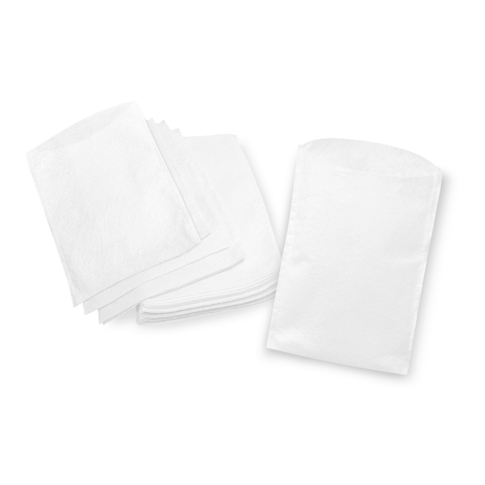 Une pile de serviettes en papier blanches soigneusement pliées à côté d'une pile de gants de toilette jetables Meditrade non pliés, le tout placé sur un fond blanc.