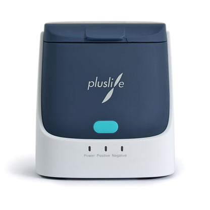 Le dispositif de test PoC-NAT Pluslife Mini Dock est un appareil électronique compact, gris foncé et blanc, avec le logo « pluslife ». Il fournit des résultats de test précis en laboratoire pour des tests au point de soins grâce à son bouton bleu et ses trois voyants de contrôle portant les mentions « Power », « Positif » et « Négatif ».