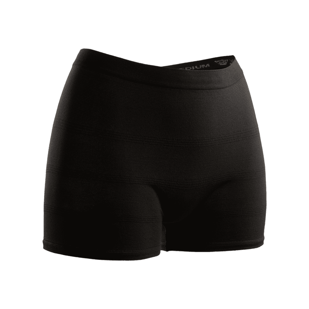 Seni Fix Comfort Lady shorts de compression noirs sur fond blanc, avec une coupe ajustée et une ceinture élastique, conçus pour un usage sportif. Le logo de TZMO Deutschland GmbH est visible à la taille. Idéal comme culotte de fixation pour un port sécurisé