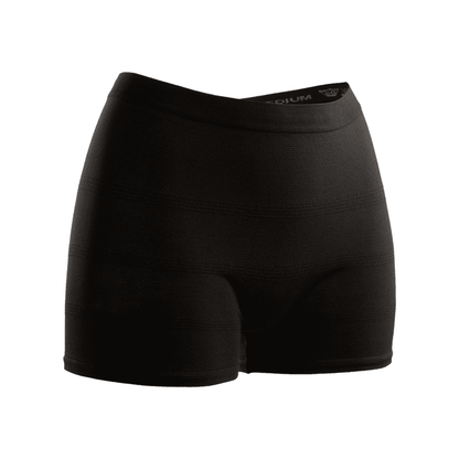 Seni Fix Comfort Lady shorts de compression noirs sur fond blanc, avec une coupe ajustée et une ceinture élastique, conçus pour un usage sportif. Le logo de TZMO Deutschland GmbH est visible à la taille. Idéal comme culotte de fixation pour un port sécurisé