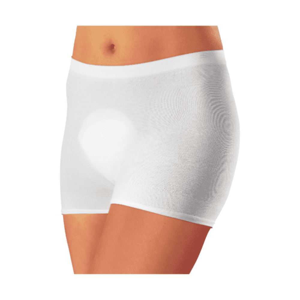 Un gros plan d'une personne portant un boxer blanc moulant « Seni Fix Comfort culottes de fixation élastiques » de TZMO Deutschland GmbH, avec un focus sur la zone de la taille jusqu'au milieu de la cuisse sur un fond blanc.