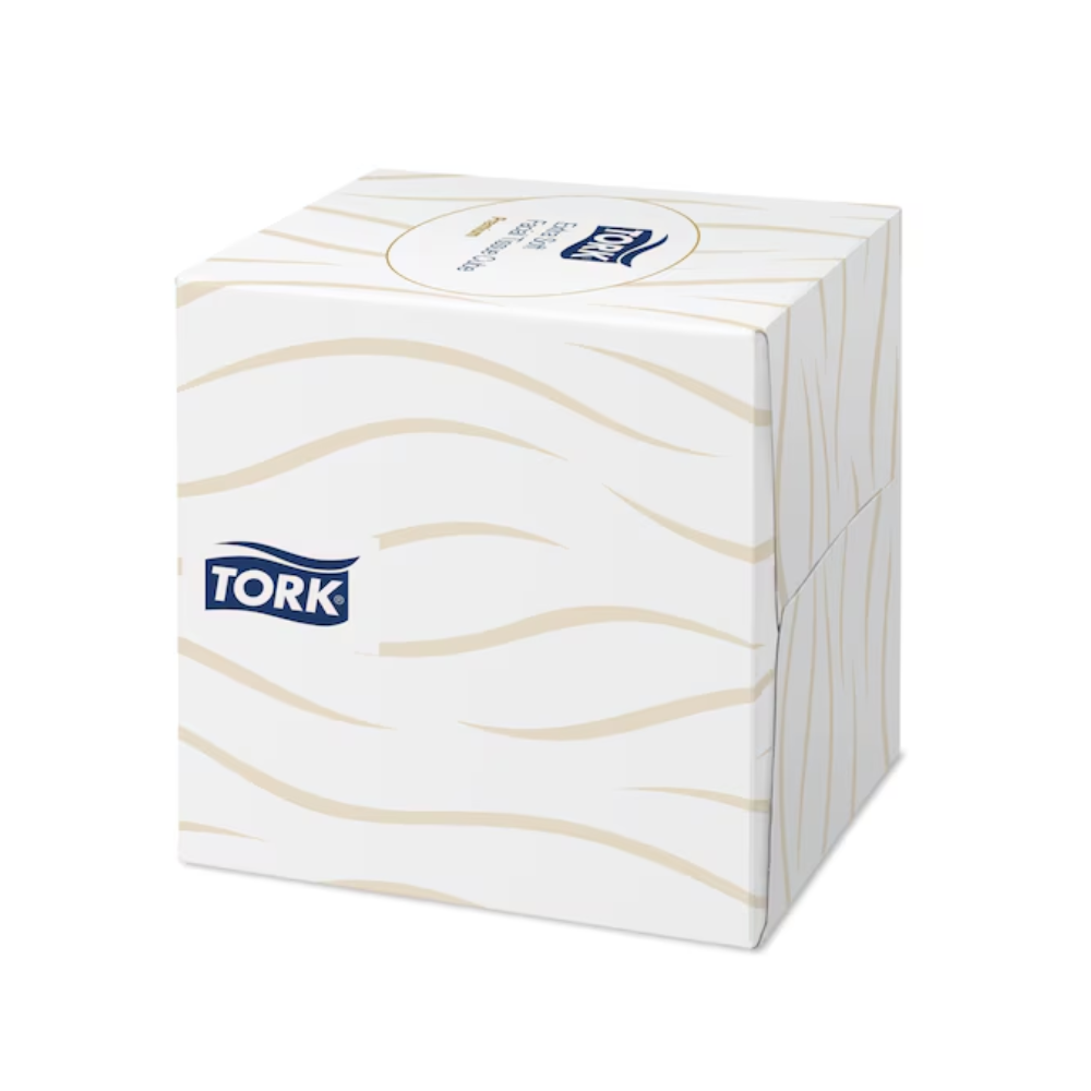 Un cube distributeur de mouchoirs Tork 140278 Tork extra doux en blanc avec un motif ondulé beige et le logo TORK sur le côté.