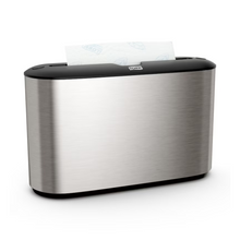 Le distributeur de table Tork Xpress® 460005 pour serviettes multifold de Essity Professional Hygiene Germany GmbH se distingue par un design en acier inoxydable sophistiqué. Son extérieur argenté métallique est accentué par un dessus noir, avec une section de serviettes en papier blanches qui émerge élégamment de la fente supérieure. Idéal pour les utilisateurs de serviettes multifold qui apprécient à la fois le style et la fonctionnalité.