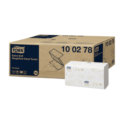 L'emballage des essuie-mains en zigzag extra-doux Tork 100278 Premium H3 à deux couches allie, grâce à son design marron et blanc, hygiène et élégance. La grande boîte marron présente les détails du produit, tandis que la petite boîte blanche met en valeur le design des essuie-mains Premium H3, orné de motifs de feuilles vertes et du logo Tork, qui représente la marque TORK – Essity Professional Hygiene Germany GmbH.