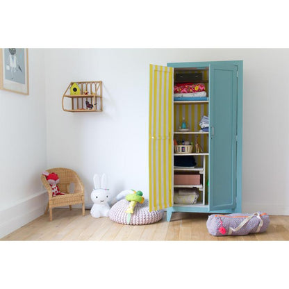 Une chambre d'enfant avec une armoire bleue, une chaise en osier et des jouets - décorez ou organisez avec du Scotch® ruban de masquage pour surfaces délicates de 3M Deutschland GmbH, qui s'enlève en douceur et sans résidus et offre un plaisir créatif.