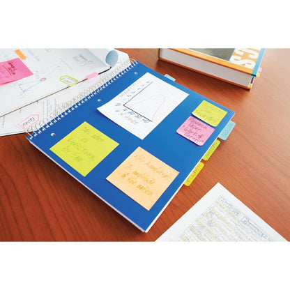 Un cahier à spirale bleu avec des notes Post-it® de 3M Deutschland GmbH en différentes couleurs néon (38x51 mm, 100 feuilles/bloc, 3 blocs/paquet) est posé sur une table en bois, à côté de papiers et d'un manuel scolaire.
