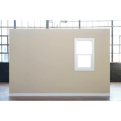 Un mur beige avec une fenêtre encadrée de blanc se trouve devant de grandes fenêtres industrielles - idéal pour peindre avec le ruban de masquage Scotch® Classic, 24 mm x 50 m, de 3M Deutschland GmbH (70% PEFC, SGSCH-COC-110078) - dans une grande pièce avec un sol en bois.