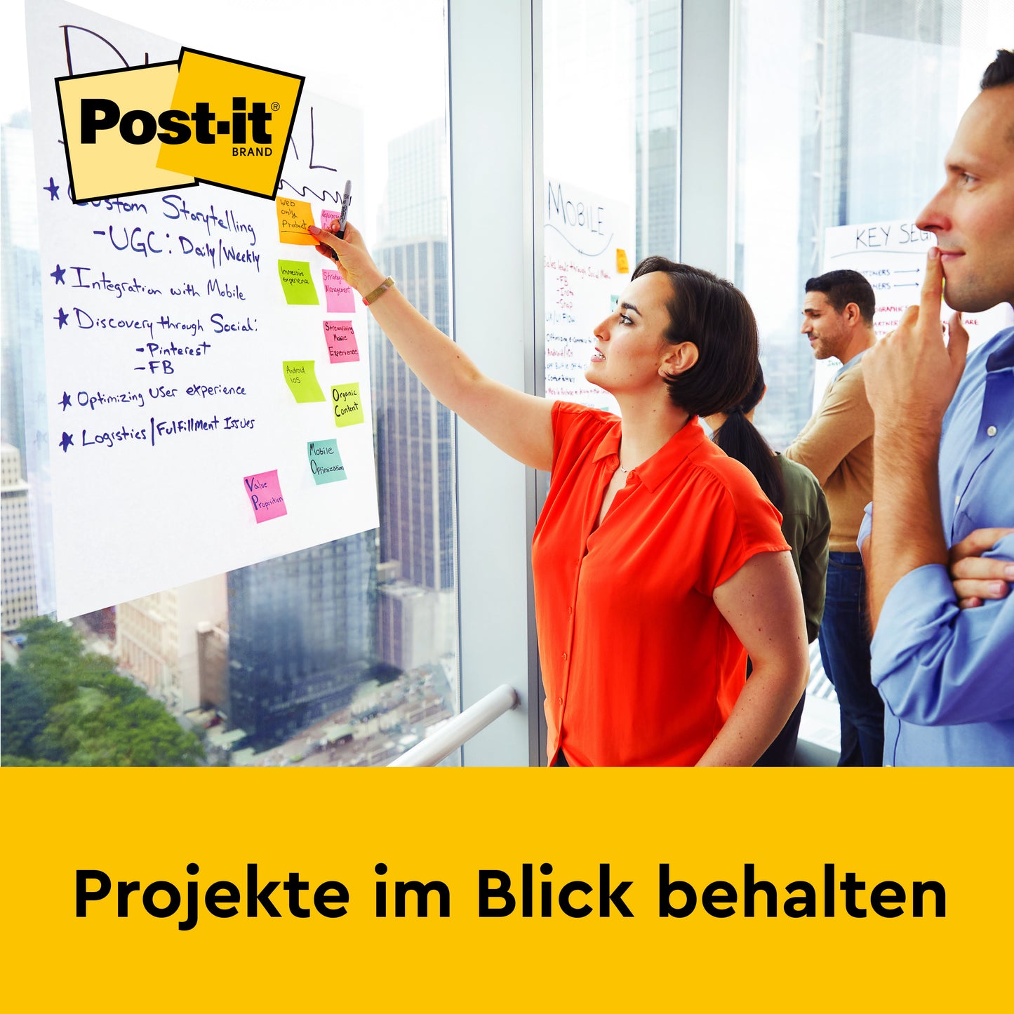 Eine Frau schreibt vor Kollegen auf einem 3M Post-it® Super Sticky Meeting Chart/Flipchart 559P (63,5 x 76,2 cm, Weiß); zu sehen sind das Post-it-Logo und ein gelbes "Projekte im Blick behalten"-Banner. Inklusive neonfarbener Notizen, PEFC-zertifiziert.