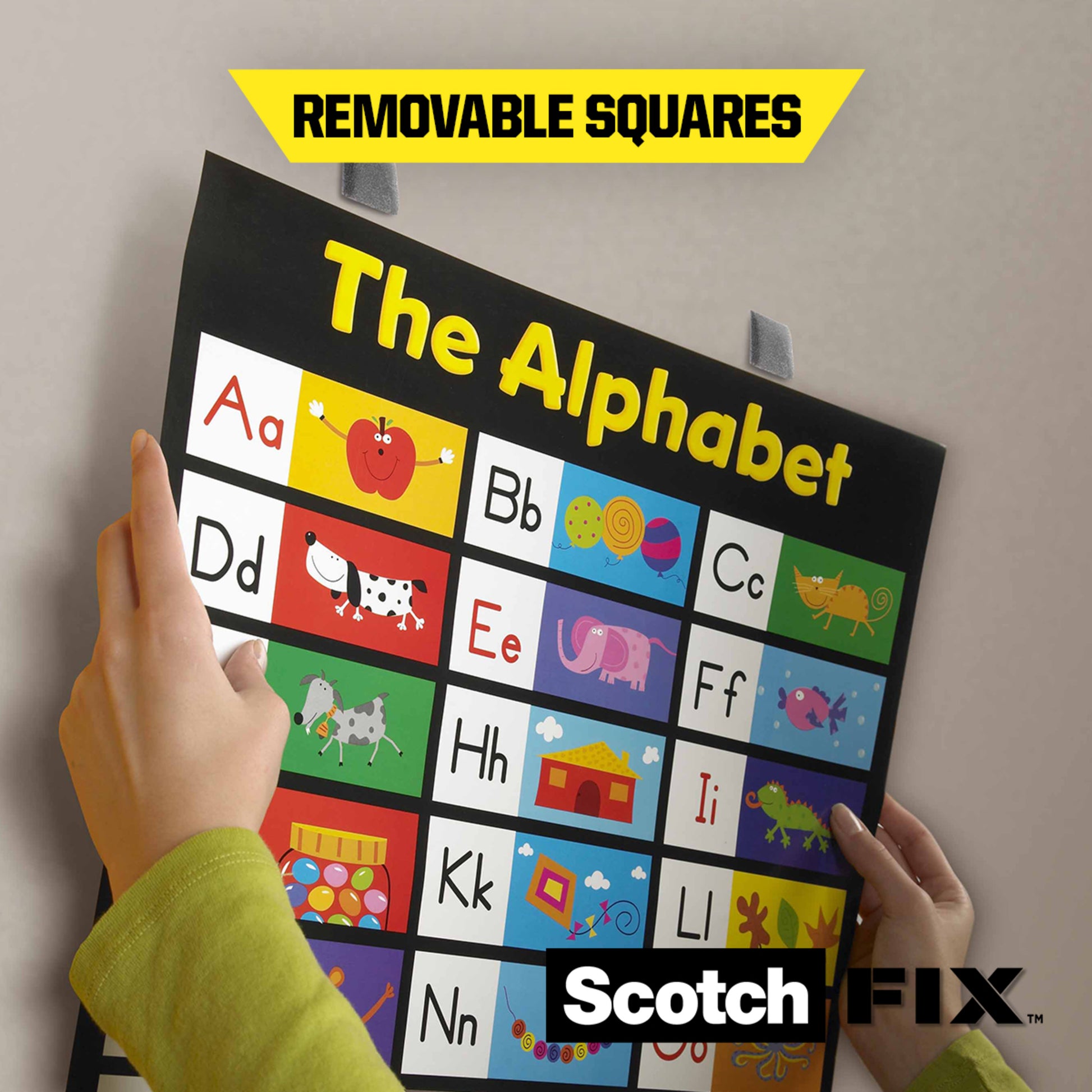 Eine Person klebt eine Buchstabentafel mit Buchstabenbildern und dem Text "REMOVABLE SQUARES" mit Scotch-FIX™ Ablösbare Montagequadrate 108-ST64-P (12,7mm x 12,7mm, 64 Stück) von 3M Deutschland GmbH. Das Scotch Fix-Logo erscheint am unteren Rand der Karte.