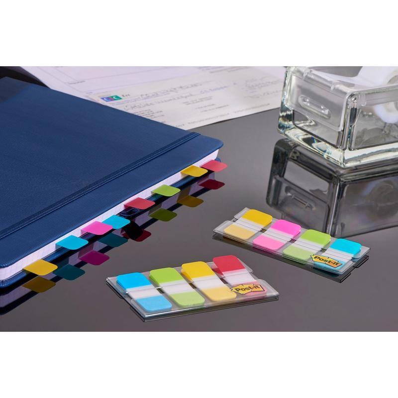Post-it® Index Strong Onglets de classement de 3M Deutschland GmbH en bleu, violet, rose et jaune (15,8 mm x 38,1 mm) sont fixés sur le classeur bleu ; deux paquets pour une organisation efficace des documents sont posés sur la table.