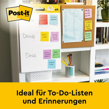 Sur le bureau se trouve un tableau de réunion auto-adhésif Post-it® Super Sticky/flipchart de 3M Deutschland GmbH (blanc, 63,5 x 76,2 cm), parfait pour les listes de tâches et les rappels. En arrière-plan : un tableau d'affichage avec du papier bleu.