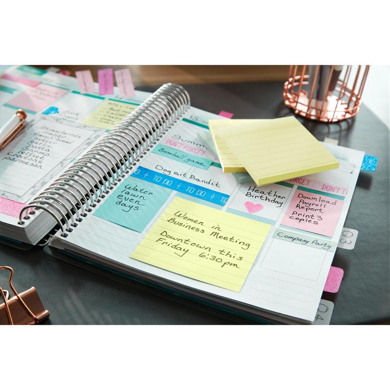 Un planificateur ouvert avec des notes, des rappels et un Post-it® Note jaune grand format (101 mm x 152 mm) de 3M Deutschland GmbH est le point fort d'une "Réunion Women in Business" le vendredi à 18h30 au centre-ville. Des stylos et un organiseur en fil métallique sont prêts.