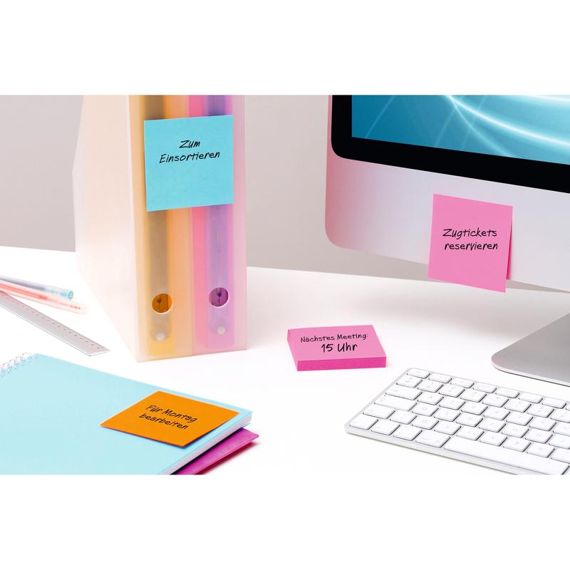 Un bureau rangé avec deux classeurs à anneaux, un moniteur, un clavier, une règle, un carnet et des Post-it® Super Sticky Notes colorés (76 mm x 127 mm, 90 feuilles/bloc, 100% PEFC) de 3M Allemagne GmbH avec des rappels manuscrits en allemand.