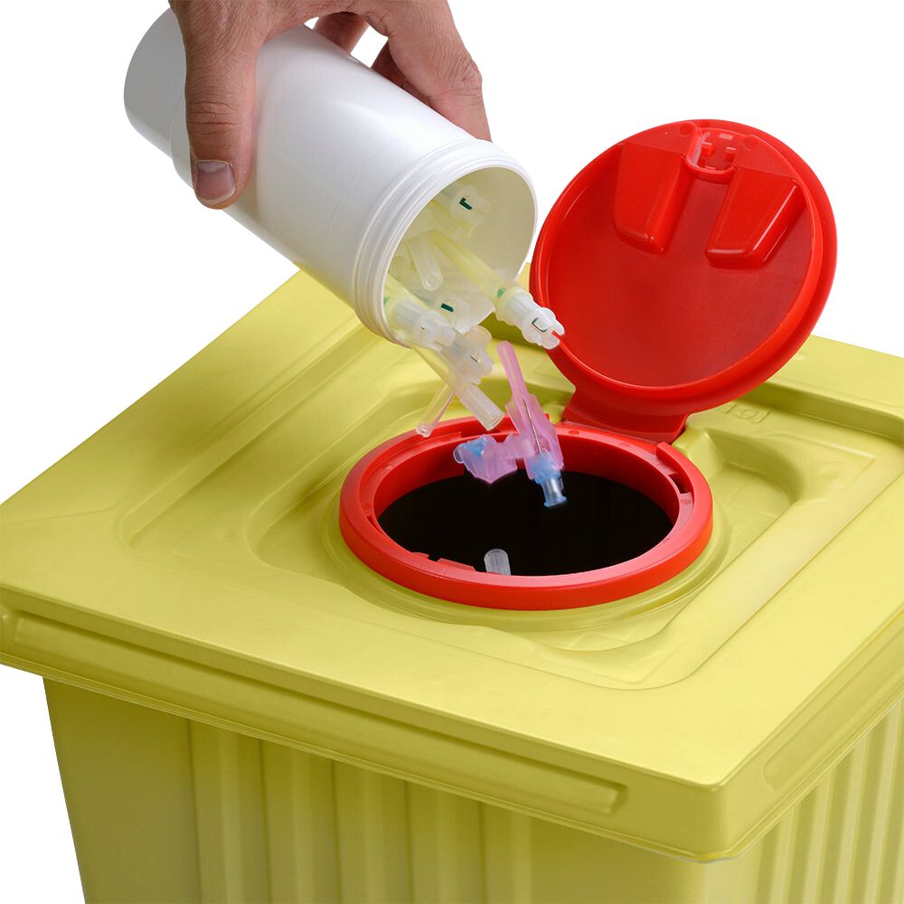 Une main élimine des pointes de seringues usagées d'un conteneur blanc de 12 L Helmut Schwarz GmbH melijekt dans un conteneur jaune pour déchets médicaux avec un couvercle rouge, assurant ainsi une élimination correcte.